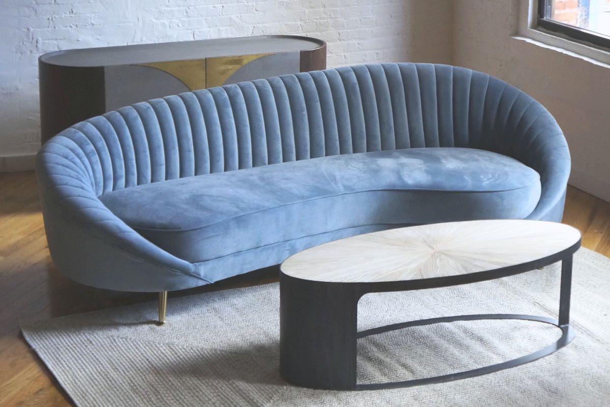 curved light blue velvet sofa, unique credenza, round wood coffee table