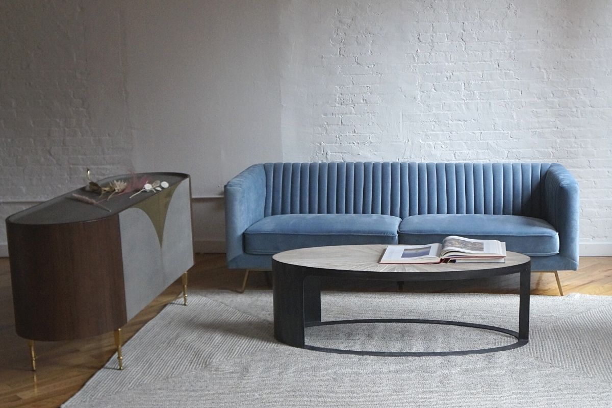 Light blue velvet modern couch with vintage coffee table and mid-century modern credenza