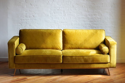 comfortable midcentury modern sofa in retro yellow velvet