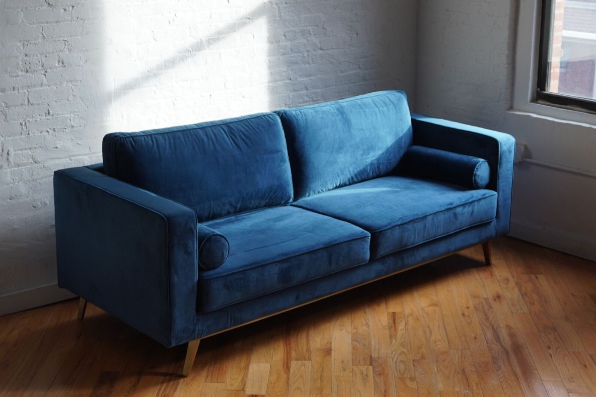 Introspect Royal blue velvet couch with matching bolsters and brass feet forward view, modern couch, mid-century modern couch product image