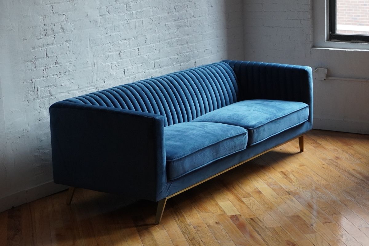Stately navy blue velvet ribbed couch with gold legs, product image side view