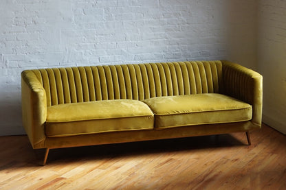 three seat sofa in mustard yellow velvet with brass finish legs